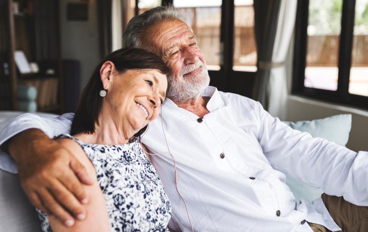 Older couple sitting close togethe on couch