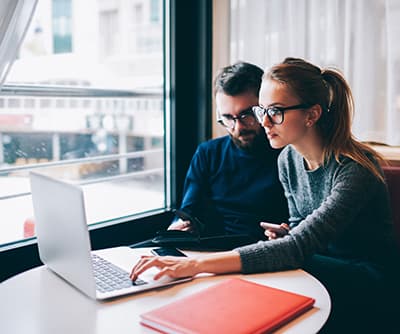 Couple In Glasses Sharing Laptop