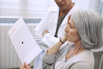 Woman checking for AMD with Amsler Grid